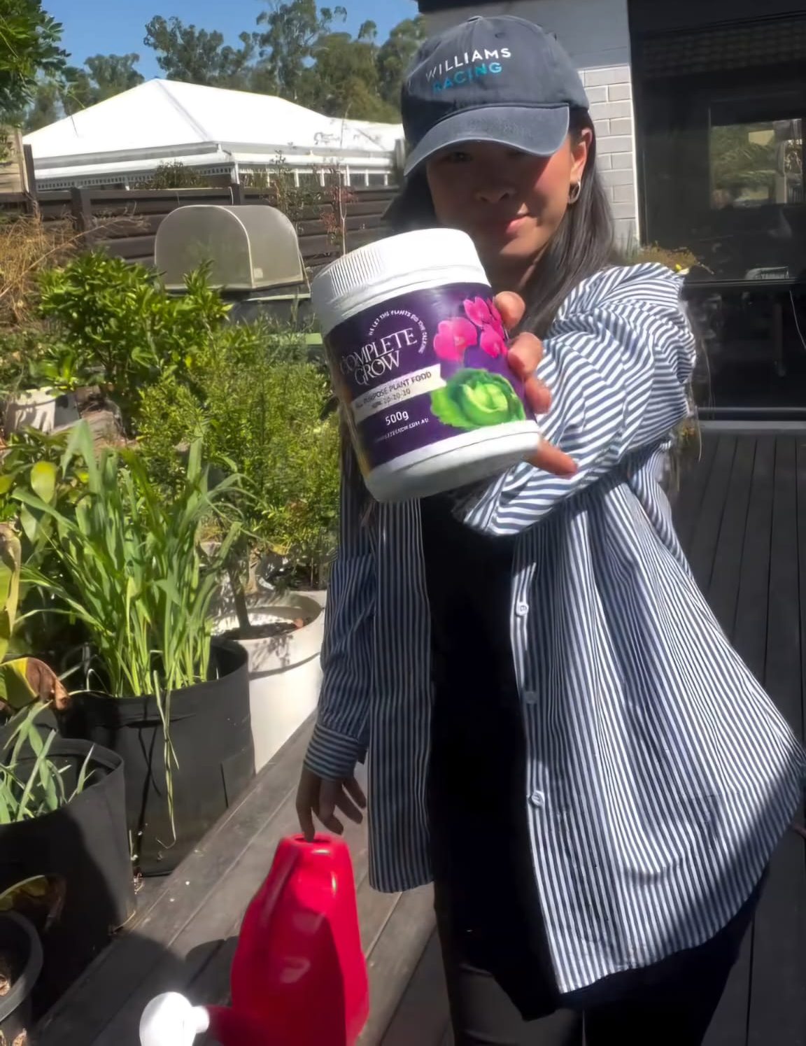 Customer holding CompleteGrow plant food in their garden
